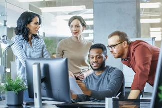 Business professionals reviewing work at computer