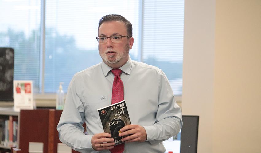 John J. Murray holding his book, "Better than our dogs"