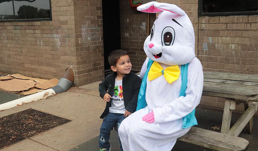 Mr. Bunny taking a picture with a little boy.