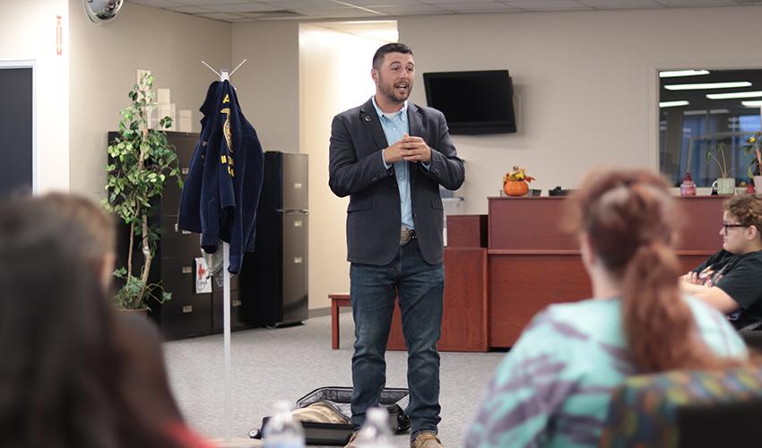 Tyler Froberg standing in front of the audience giving his presentation.